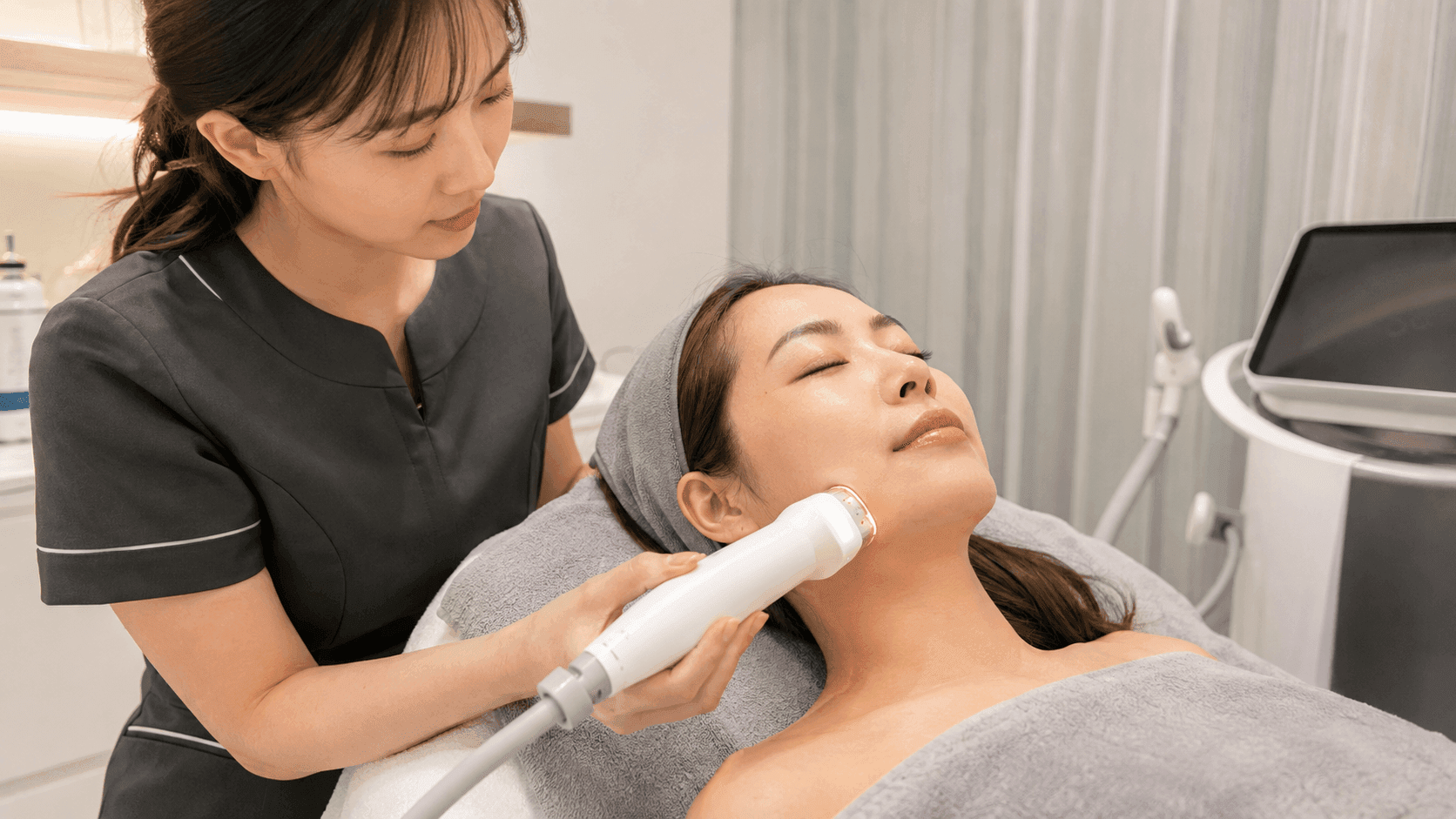 美容師使用專業醫美儀器為女性顧客進行臉部提拉與皮膚護理療程